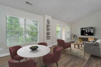 A living room with a white table and red chairs.